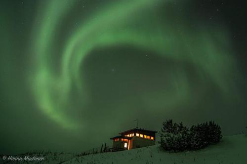 a house under the aurora in the sky at Lumikko Aurora Loft in Enontekiö