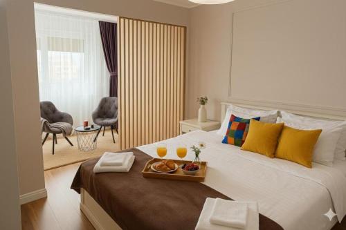 a bedroom with a bed with a tray of fruit on it at Mid Velvet Apartment, Free Parking, Self Check-in in Oradea