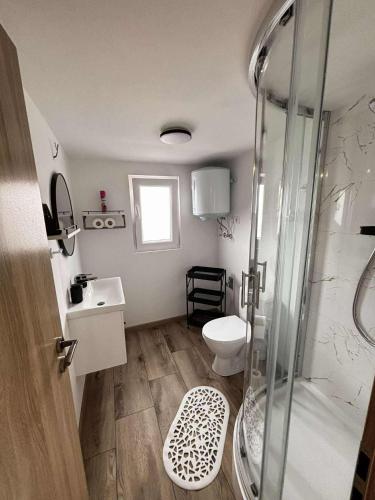 a bathroom with a shower and a toilet and a sink at Moon apartments in Pakoštane