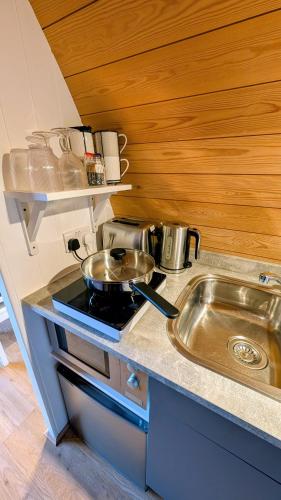 a small kitchen with a stove and a sink at Glamping at Honnington Farm in Royal Tunbridge Wells