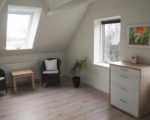 a room with a dresser and a chair and a window at Sommerliv Bed and Breakfast in Tranekær