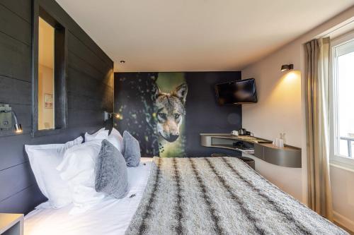 a bedroom with a bed with a painting of a giraffe at Les Loges Du Parc in Gérardmer