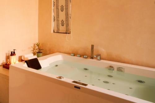 a large bath tub in a bathroom with at Niwasa - A Luxury Boutique Stay, Udaipur in Udaipur