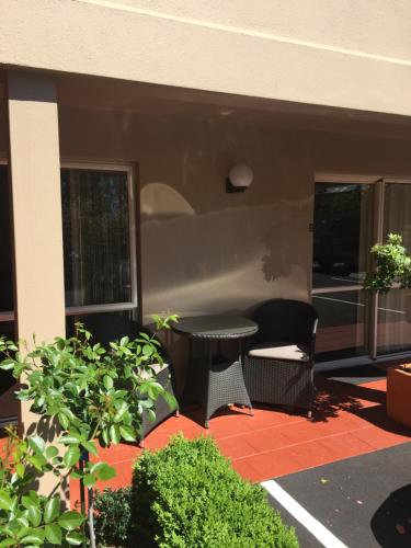 a patio with a table and chairs on a building at Tuscana Motor Lodge in Christchurch