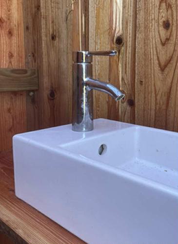 a white sink with a faucet on top of it at Stenbækgård - Farm Glamping in Højslev