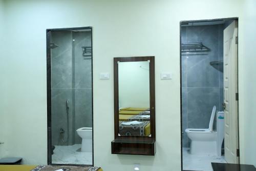 a bathroom with a mirror and a toilet at Ganga Regency in Solapur