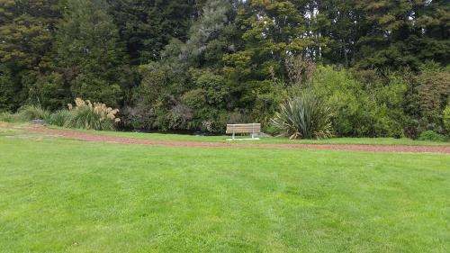 a park bench sitting in the middle of a field at Snowhaven in Ohakune