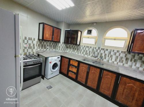 a kitchen with a washer and dryer at comfort stay 205 in Al Ain