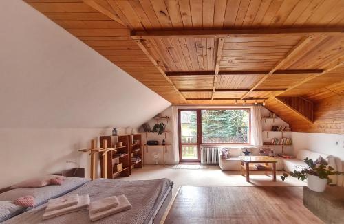 a bedroom with wooden ceilings and a large window at Penzion Bor in Náchod
