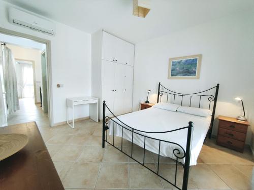 a white bedroom with a black bed and a table at Sunset View in Polis Chrysochous