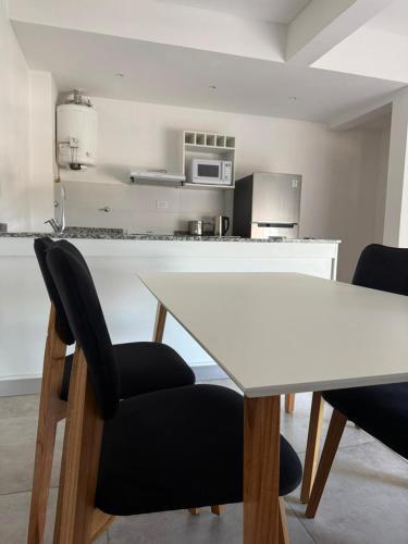 a kitchen with a white table and two chairs at Altostay in Villa Constitución
