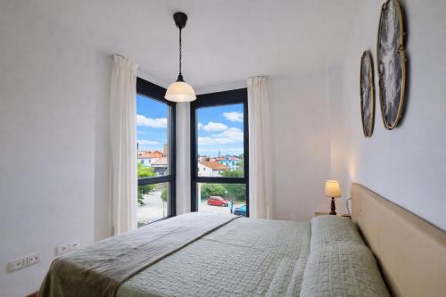 a bedroom with a bed and a large window at Llanes Celorio Piscina y Playa – El Castro Borizu in Celorio
