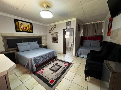 a hotel room with a bed and a couch and a living room at Tana B Guesthouse in Welkom