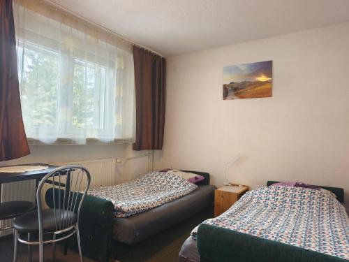 a room with two beds and a chair and a window at Męcikówka in Szczyrk
