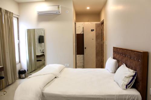 a bedroom with a large bed and a mirror at Shagun Hotel & Banquet in Lucknow