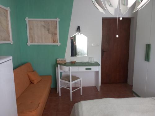 a room with a table and a couch and a mirror at Guest House Green Corner Supetarska Draga in Supetarska Draga