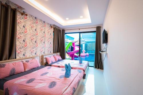 a hotel room with two beds and a tv at Flamingo Na Jomtien in Na Jomtien