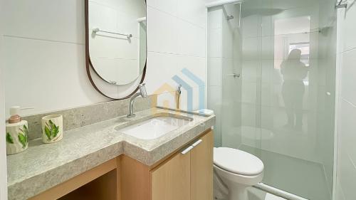 a bathroom with a sink and a toilet and a mirror at Unigreen Manaíra Genius Flats in João Pessoa