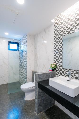 a bathroom with a sink and a toilet and a mirror at Flamingo Na Jomtien in Na Jomtien