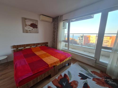 a bedroom with a colorful bed and a large window at Large Two Floor Apartment in Byala