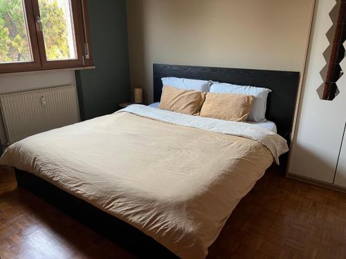 a bedroom with a bed with white sheets and pillows at Pegaso - bilocale a pochi passi dal centro in Pordenone