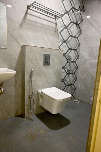 a bathroom with a toilet and a sink at SR Grand in Tumkūr