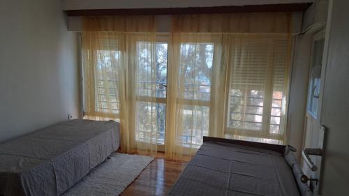 a bedroom with a bed and a large window at Apartmani Primorski hrast in Bar