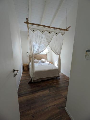 a bedroom with a bed with a canopy at Gîtes l'orée Bleue in Sainte-Rose
