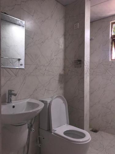 a white bathroom with a toilet and a sink at Slayan properties in Gampaha