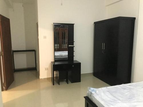 a bedroom with a bed and a dresser and a mirror at Slayan properties in Gampaha