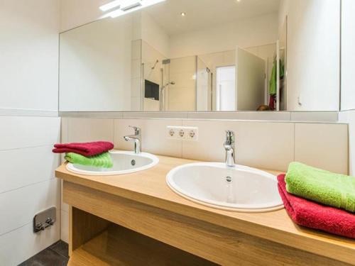 a bathroom with two sinks and a large mirror at Ferienhof Raither in Immenstaad am Bodensee