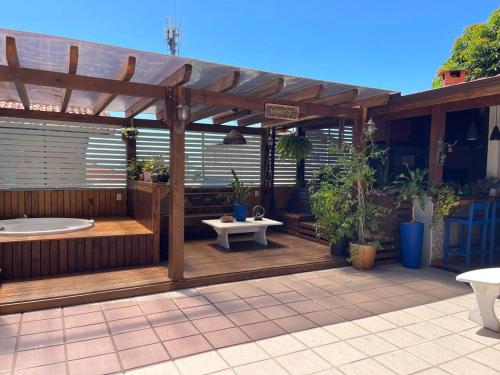 a wooden pergola with a tub on a patio at Hostel House Santinho in Florianópolis