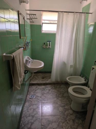 a green bathroom with a toilet and a sink at Casa de la Bove in La Cumbre