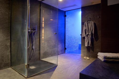 a bathroom with a shower and a robe hanging on a wall at Ajax Hotel in Limassol