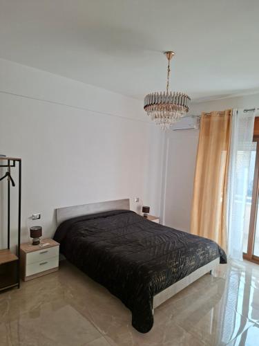 a bedroom with a black bed and a chandelier at La sirena in Mazara del Vallo