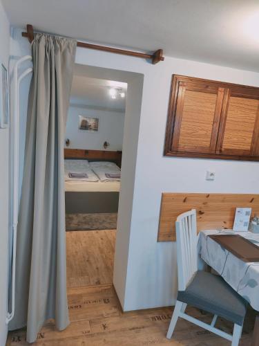 a room with a bed and a table and a chair at Apartmán Astomo in Vrchlabí