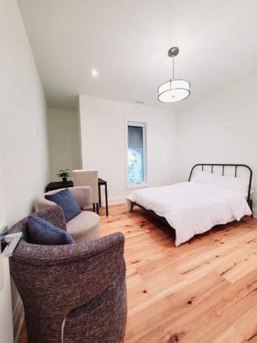 a bedroom with a bed and a couch and chairs at Executive Room in Toronto next to Yorkdale shopping centre in Toronto