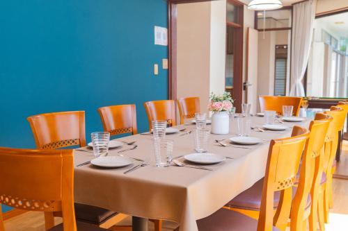 a long table in a room with orange chairs at 高崎の宿 つどい in Takasaki