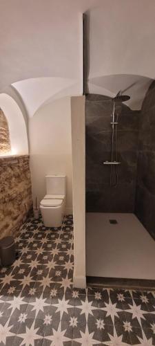 a bathroom with a toilet and a black and white floor at Palacio de los Angulo casa histórica en el centro de Córdoba in Córdoba