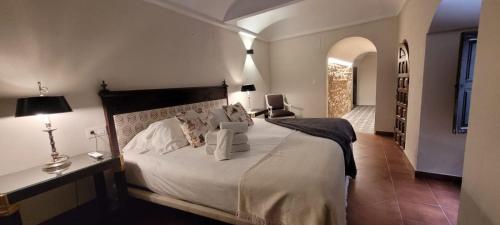 a bedroom with a large white bed and a hallway at Palacio de los Angulo casa histórica en el centro de Córdoba in Córdoba