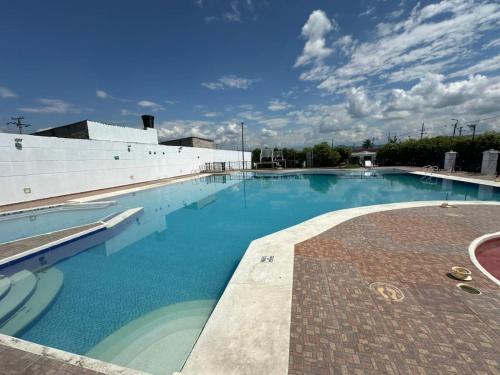 a large swimming pool with blue water in front of a building at Casa Los Mangos 4 Piscinas 6 Camas y mucho Sol in Flandes
