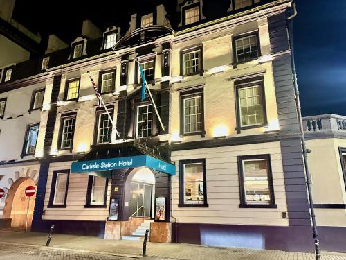 a large white building with flags in front of it at Carlisle Station Hotel, Sure Hotel Collection by BW in Carlisle