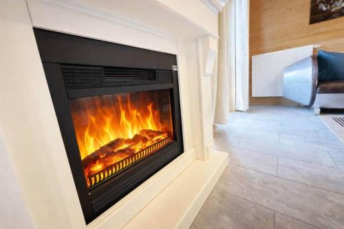a fireplace in a living room with flames in it at Sky-View Chalet am Waldsee in Rieden