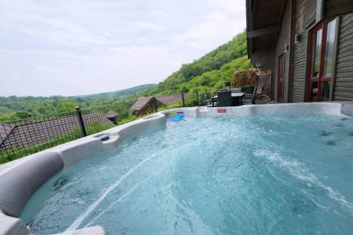 a hot tub with a view of the mountains at Sky-View Chalet am Waldsee in Rieden