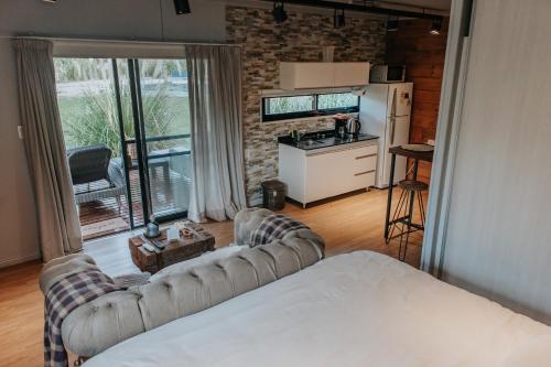 a living room with two couches and a kitchen at OMM Suites Resort, Villa General Belgrano in Villa General Belgrano