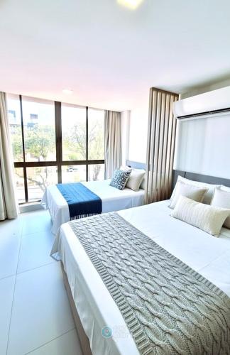 two beds in a hotel room with a large window at Get Sense By 123Quarto Hospedagem in João Pessoa