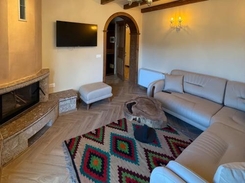 a living room with a couch and a fireplace at Hotel Restorant Unaza in Voskopojë