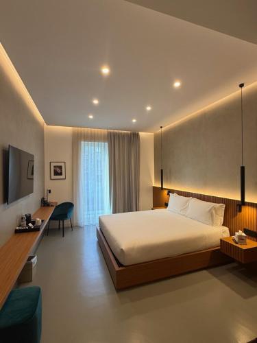 a hotel room with a large bed and a desk at J Maluni City Hotel in Rome
