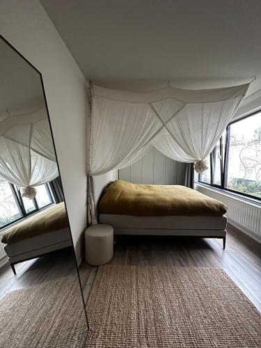 a bedroom with a canopy bed and a mirror at Maastricht House Anne in Maastricht