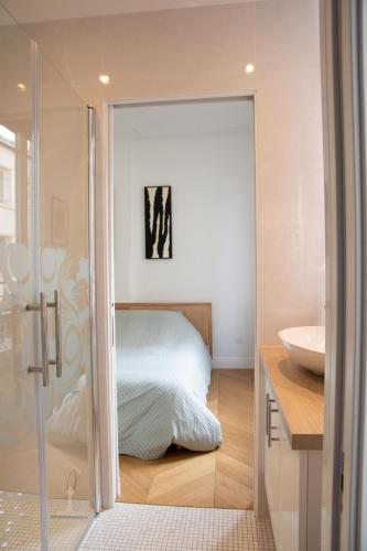 a bedroom with a bed and a sink and a mirror at Au bonheur de Troyes in Troyes